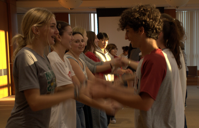 Students in the middle of clapping hands as they prepare for another round of line dancing.